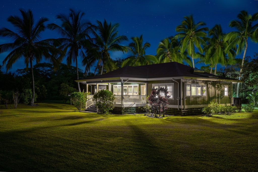 Our beautiful Hana listing glows under the Palm trees on a moonlit night. 