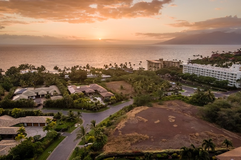 A drone shot shows the sun starting to set. Our vacant land listing in Palauea is in the foreground. 