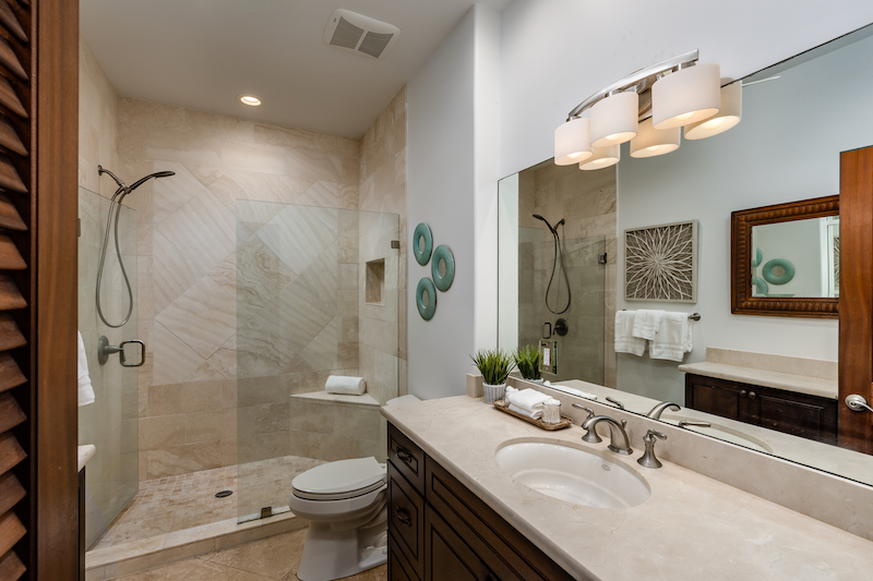 The bathroom off the primary bedroom includes a large cabinet with extensive storage, a walk in shower and granite counters. 