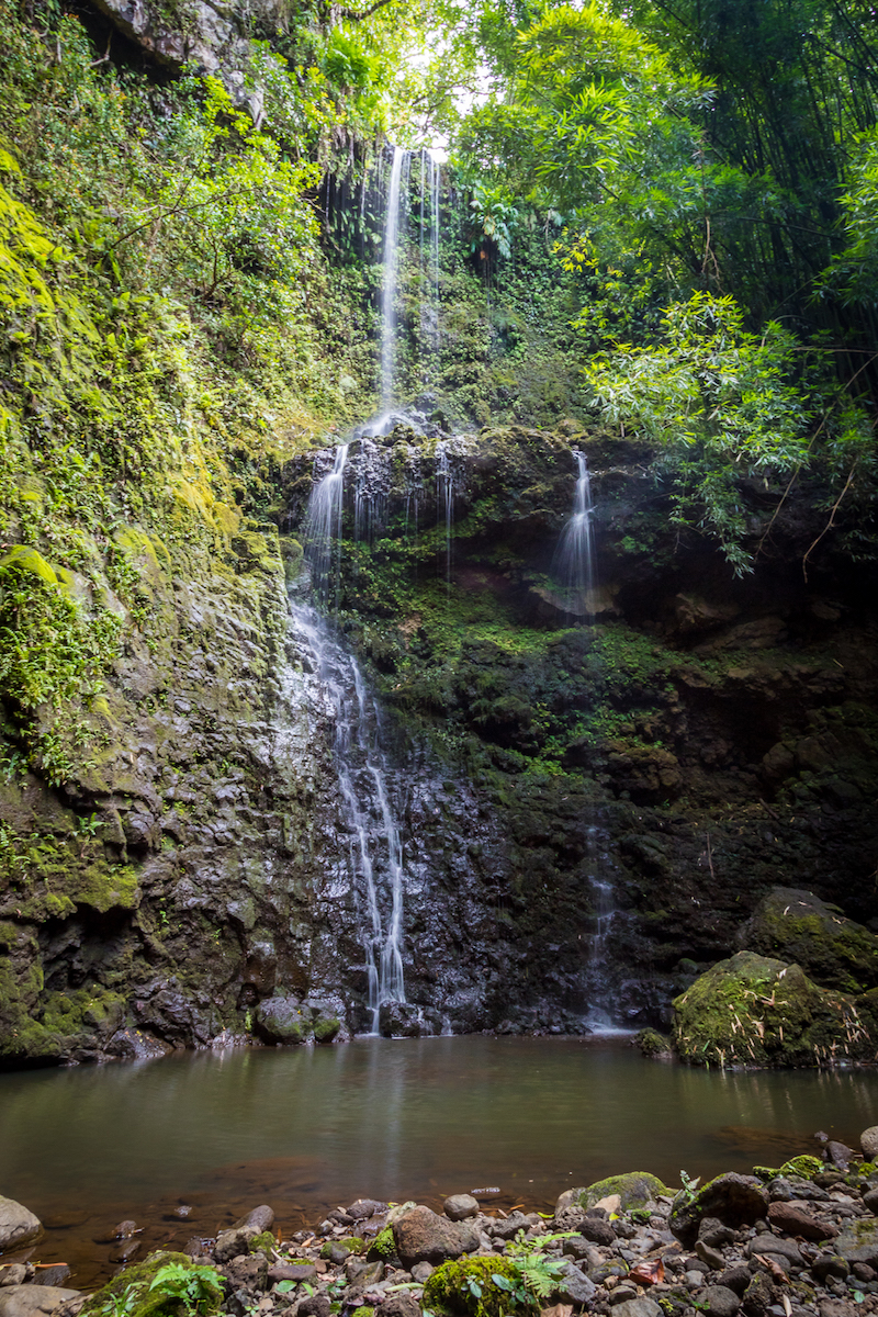 A waterfall trickles into a quiet pool in Hanawana Valley