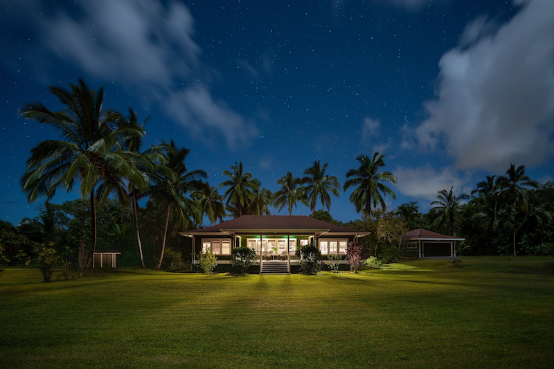 Hana Home flanked by Palm Trees under the moonlight