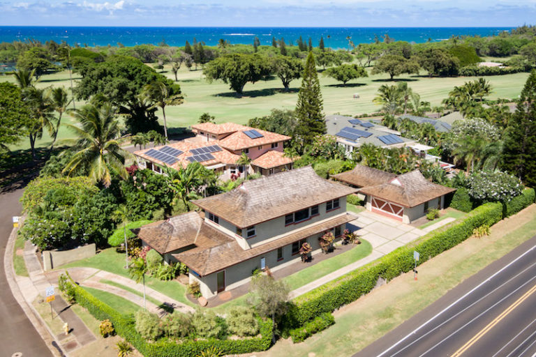 this aerial shot of 10 ulupua shows the home, detached garage, the maui country club golf course with the ocean on the other side of the golf course